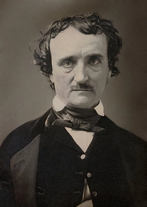 Black and white photograph of a middle aged man with unkempt hair, a mustache and a Victorian styled suit.